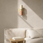 Beige and pink double Scandinavian wall sconce above an American linen sofa