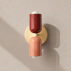 Red and pink double Scandinavian wall sconce on a light taupe wall
