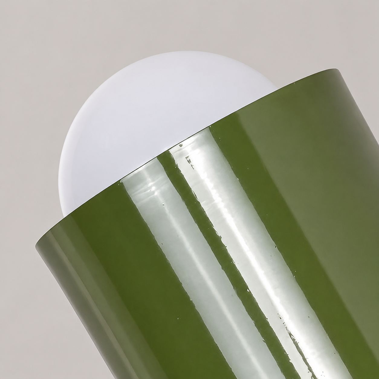 Close detail of the green shade and globe on a Scandinavian wall sconce