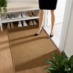 Brown faux jute doormat beside a shoe bench as a person steps into the entryway.