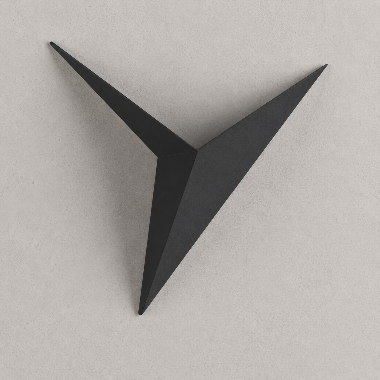 Black geometric star LED wall sconce on a warm light-gray wall