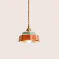 Terracotta hand-painted ceramic pendant light on an off-white studio background