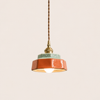 Terracotta hand-painted ceramic pendant light on an off-white studio background