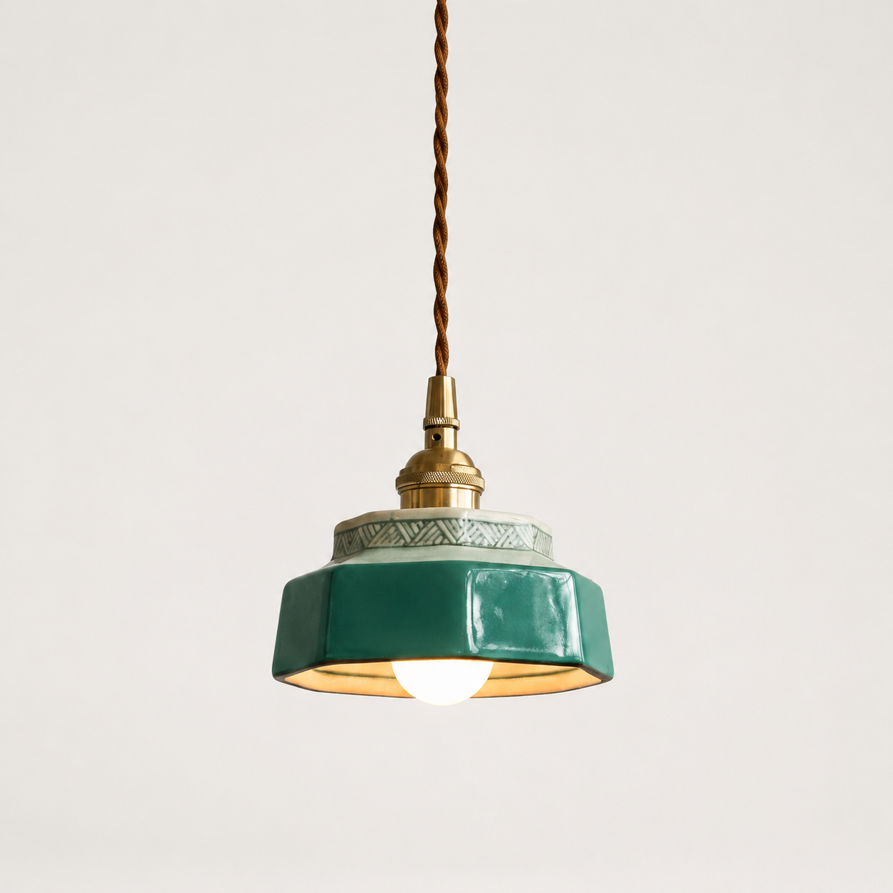 Blue-green hand-painted ceramic pendant light on an off-white studio background