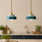 Two blue-green hand-painted ceramic pendant lights above a shaker kitchen counter