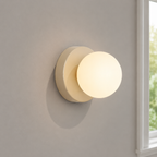 Close view of a beige Nordic glass globe wall sconce on a stone-gray wall