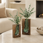 Two live edge wood vases with green glass inserts and eucalyptus stems