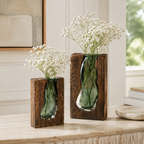 Pair of wood-framed green glass vases filled with white baby's-breath flowers