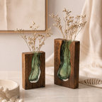 Two Nordic wood and green glass vases with delicate dried stems