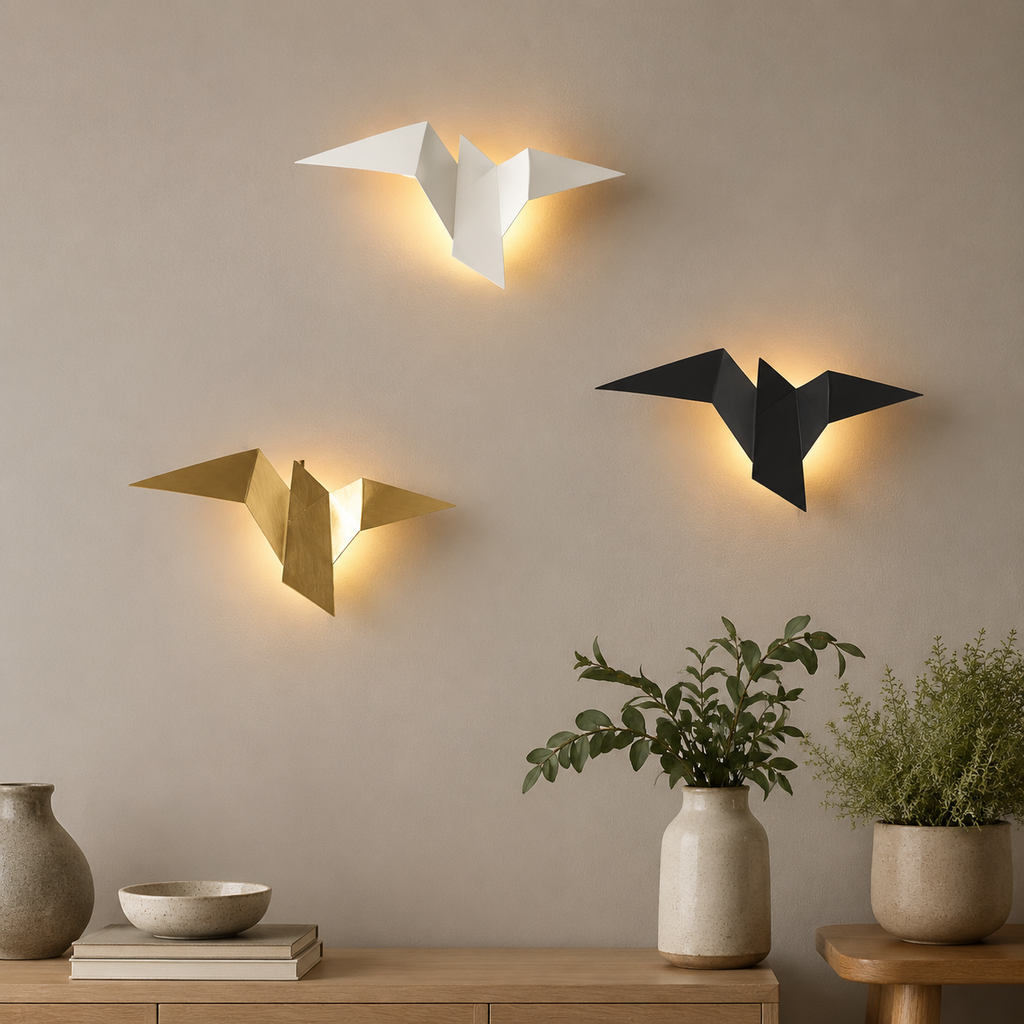 White black and gold origami bird LED wall sconces glowing above a console