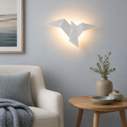 White origami bird LED wall sconce glowing in a blue-gray sitting area