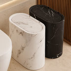 Cream and black marble oval trash cans arranged together in a bathroom