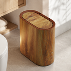 Wood grain oval trash can beside light oak bathroom shelving