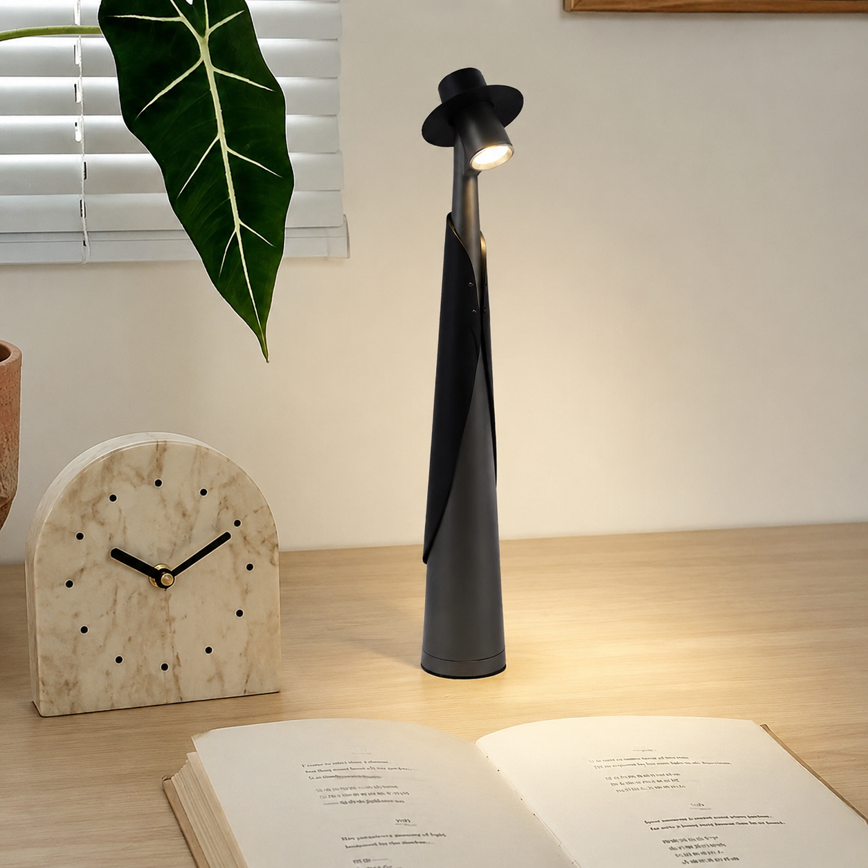 Deep grey rechargeable LED hat lamp glowing on a pale oak desk.