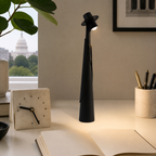 Black rechargeable LED hat lamp on a bright modern home office desk.