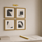 Gold rechargeable picture light charging on a quartz console beneath gallery art