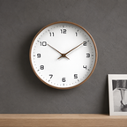 Brown wood frame wall clock mounted on a deep gray plaster wall