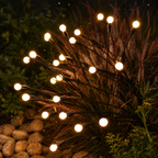 Close view of solar garden light stems glowing among fountain grass