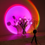 Black sunset projector lamp casting a magenta halo behind white tulips