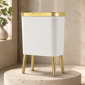 White trash can variant with gold trim on a rounded limestone pedestal.