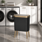 Black trash can with elevated gold legs in a bright American laundry room.