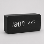 Black block LED alarm clock on a neutral gray studio background