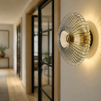 Smoked gray ribbed glass wall sconce in a black framed hallway