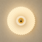 Front view of cream ribbed glass wall sconce with brass center