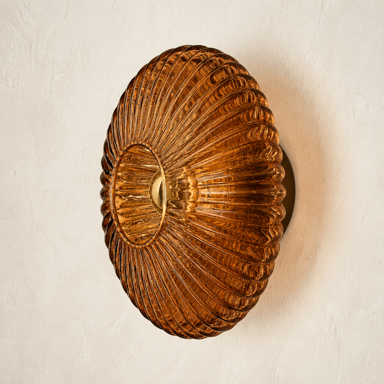 Cognac brown ribbed glass wall sconce on an ivory plaster wall