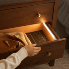 Silver wireless motion sensor LED bar lighting an open walnut dresser drawer