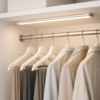 Silver wireless motion sensor LED bar glowing above a closet hanging rail